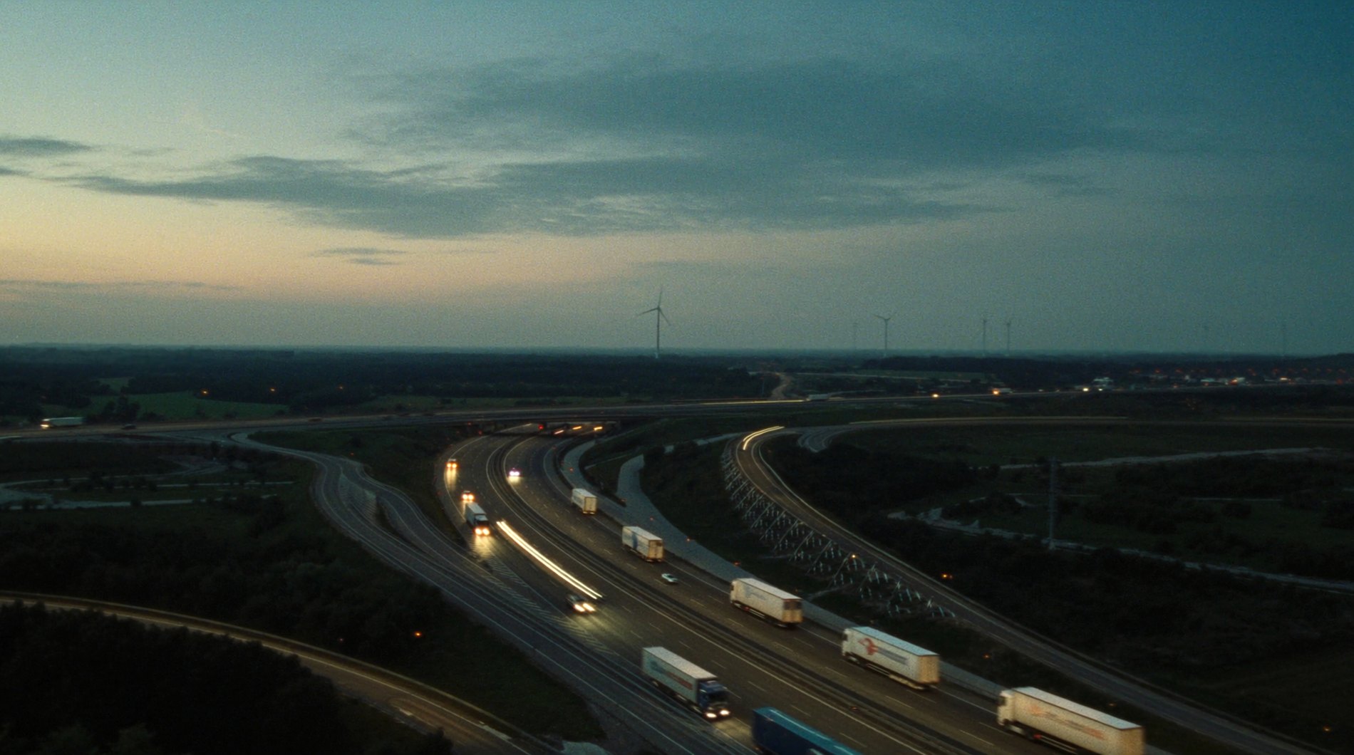 Luftaufnahme eines europäischen Autobahnkreuzes bei Dämmerung mit Güterverkehr